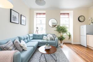 - un salon avec un canapé bleu et une table dans l'établissement Bright and modern 2 bed apartment, à Édimbourg