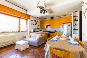 Terrazza 30 by Napoliapartments في نابولي: مطبخ وغرفة معيشة مع طاولة وأريكة