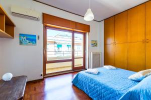 Terrazza 30 by Napoliapartments في نابولي: غرفة نوم بسرير ازرق ونافذة كبيرة