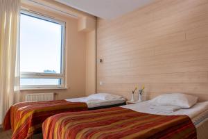 two beds in a room with a window at Center Hotel in Tallinn