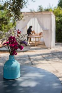 a blue vase with flowers sitting on a table at Marenea Suite Hotel - CDSHotels in Marittima