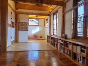 an empty room with bookshelves and windows in a building at Chaehyodang Hanok Stay in Seoul