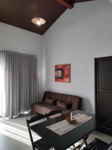uma sala de estar com uma mesa e um sofá em Pousada Refúgio da Serra em Pirenópolis