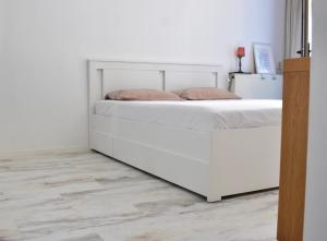 a white bed in a white room with a white wall at 010 Studio City Center Rotterdam in Rotterdam