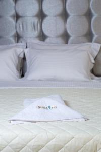 Anamar Kea Boutique في Koundouros: منشفة بيضاء موضوعة فوق السرير