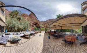 a pavilion with tables and chairs on a patio at Hotel De La Vallée in Aït Baha
