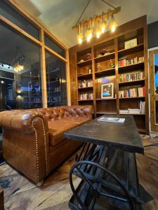 a bar with a leather couch and a table at Manali residency in Manāli