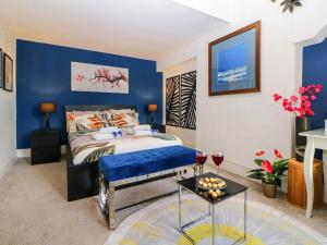ein Schlafzimmer mit einem Bett und einer blauen Wand in der Unterkunft English Riviera coastal holiday home in Devon Uk in Paignton
