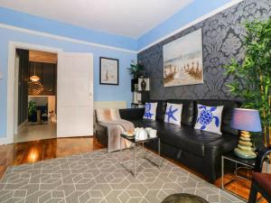 ein Wohnzimmer mit einem schwarzen Ledersofa und blauen Wänden in der Unterkunft English Riviera coastal holiday home in Devon Uk in Paignton