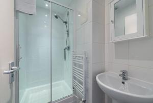 Un baño blanco con ducha y lavabo. en Downtown and central 1 bed in Edinburgh, en Edimburgo 29 fotos más