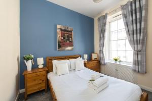 - une chambre bleue avec un lit et une fenêtre dans l'établissement Downtown and central 1 bed in Edinburgh, sleeps 4, à Édimbourg