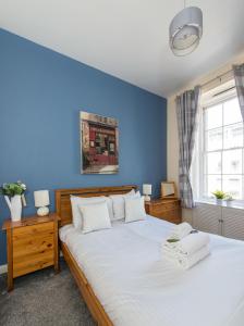 una camera con un grande letto con una parete blu di Downtown and central 1 bed in Edinburgh, sleeps 4 a Edimburgo