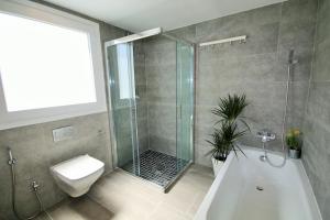 a bathroom with a shower and a toilet and a tub at Stylish Beach House in La Cala de Mijas 5 star location few steps from Butibamba Beach in La Cala de Mijas