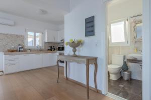 biała kuchnia ze stołem i toaletą w obiekcie Uno Luxury Apartment with Sea view w mieście Livadia