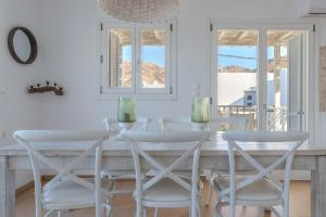 a white dining room with a table and chairs at Uno Apartment 1st Floor in Livadia