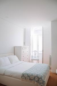 a white bedroom with a bed and a dresser at Just Like Home - Casinha da Vila em Caminha in Caminha
