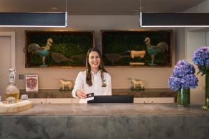 Eine Frau steht an einem Tresen in einem Salon. in der Unterkunft The Lince Nordeste in Nordeste