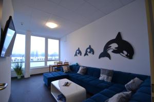 a living room with a blue couch and dolphins on the wall at Arena Hostel Hamburg in Hamburg