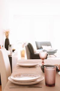 uma mesa com pratos numa sala de estar em Just Like Home - Casinhas da Vila T2 em Caminha em Caminha