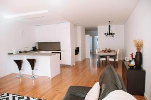 a person sitting on a couch in a living room at Just Like Home - Casinha da Vila em Caminha in Caminha +27 photos