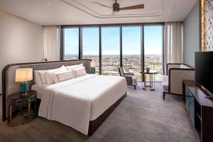 a bedroom with a large white bed and large windows at Melia Vinpearl Hue in Hue