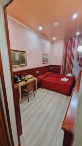 a hotel room with a red bed and a desk at New Apartment Marghera in Milan