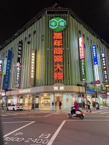 a building with signs on the side of it at night at 苓旅萬年-LIN INN Wan Nian in Taipei