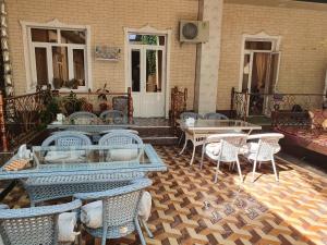 a patio with tables and chairs on a building at Hotel Jasmina in Samarkand