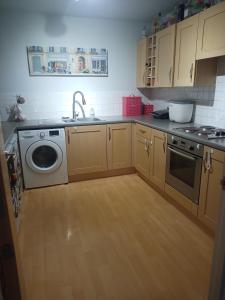a kitchen with a sink and a washing machine at Double Room in a Top Floor Shared Apartment in Northampton