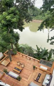 a deck with chairs and a view of a lake at Moonlight Champa Riverview in Luang Prabang