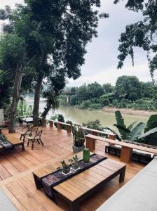 a deck with benches and a view of a river at Moonlight Champa Riverview in Luang Prabang