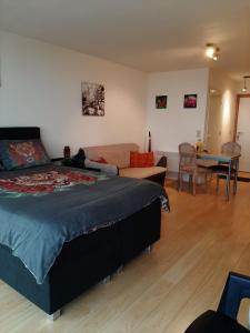 a bedroom with a bed and a couch and a table at studionusi in Blankenberge