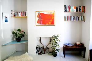 a room with a white wall with bookshelves at Large, modern, light, open plan designer house in London