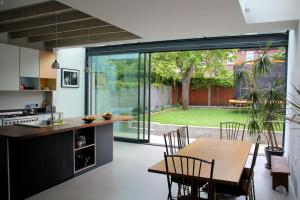 a kitchen and dining room with a table and chairs at Large, modern, light, open plan designer house in London