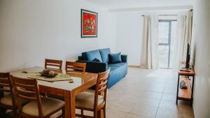 a living room with a table and a blue couch at Vista del Piltri in El Bolsón