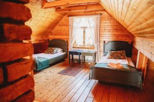 1 dormitorio con 2 camas y un escritorio en una cabaña en Skansen Bicz Resort en Stare Miasto