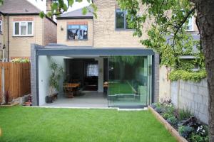a extension to a house with a lawn at Large, modern, light, open plan designer house in London