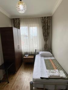 niewielka sypialnia z łóżkiem i oknem w obiekcie Ferah Otel w Stambule