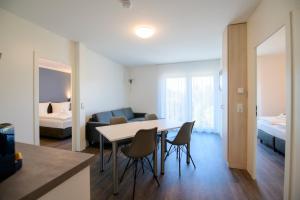 a living room with a table and chairs and a bedroom at Smart & Stay Aparthotel Saarbrücken Süd - Self-Check-In - Free Parking in Saarbrücken