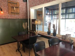 a dining room with tables and chairs and a brick wall at Hotel Norg in Norg