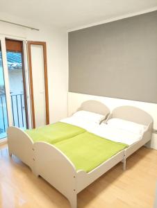 a bedroom with a white bed with a green blanket at El piset de la font in Onda