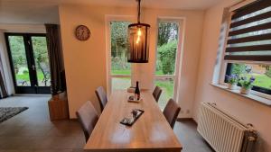een eetkamer met een houten tafel en stoelen bij Vakantiewoning Maas en Waal in Ewijk