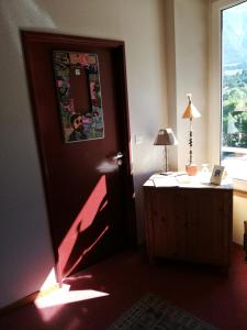 a room with a door and a desk and a window at L'Auberge d'Eygliers in Eygliers