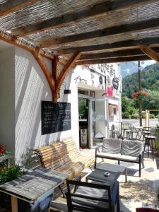 a patio with benches and a table and chairs at L'Auberge d'Eygliers in Eygliers