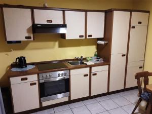 a kitchen with white cabinets and a sink and a stove at Wohnung Am Fuße des Steigerwaldes in Gerolzhofen