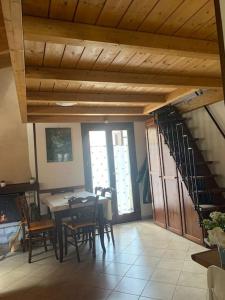 a dining room with a table and chairs and a wooden ceiling at La Loggia Luxury in Rocca di Mezzo