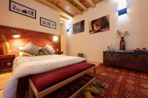 a bedroom with a bed with a red bench in it at Touda Ecolodge Atlas Mountains in Zawyat Oulmzi