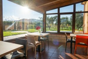 restauracja ze stołami i krzesłami oraz dużym oknem w obiekcie BB Domus Catanzaro w mieście Catanzaro
