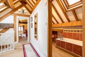 a large hallway with wooden ceilings and a bathroom with a tub at The Town House Ludlow in Ludlow