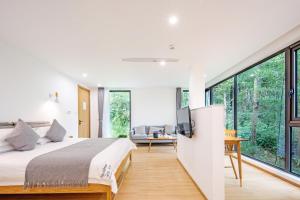 a bedroom with a large bed and a tv on a wall at Moganshan Naicang Boutique Hotel in Deqing